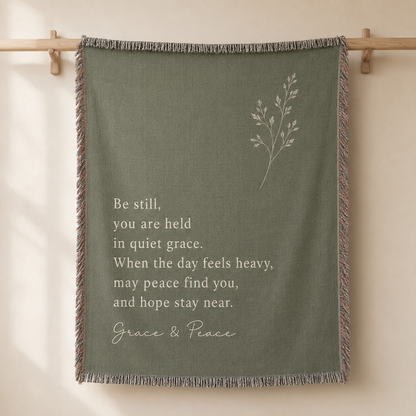 Grace and Peace sage green inspirational woven blanket displayed as a wall tapestry