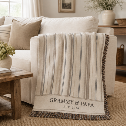 Personalized Grammy and Papa woven blanket draped over a cream sofa in a neutral living room