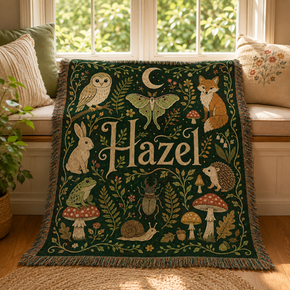 Personalized woodland name woven blanket draped on a bright window seat with pillows and greenery